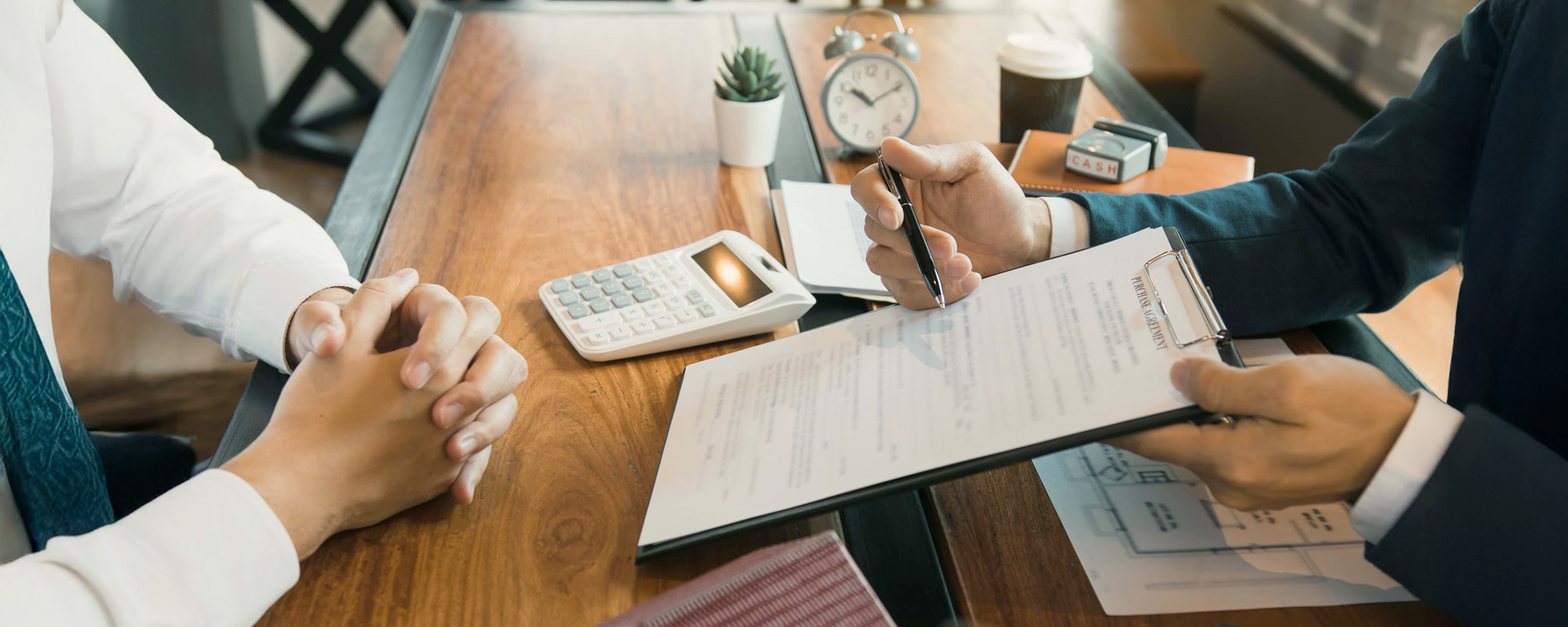 Agents are using pens pointing to contracts and are being explained to customers at the office