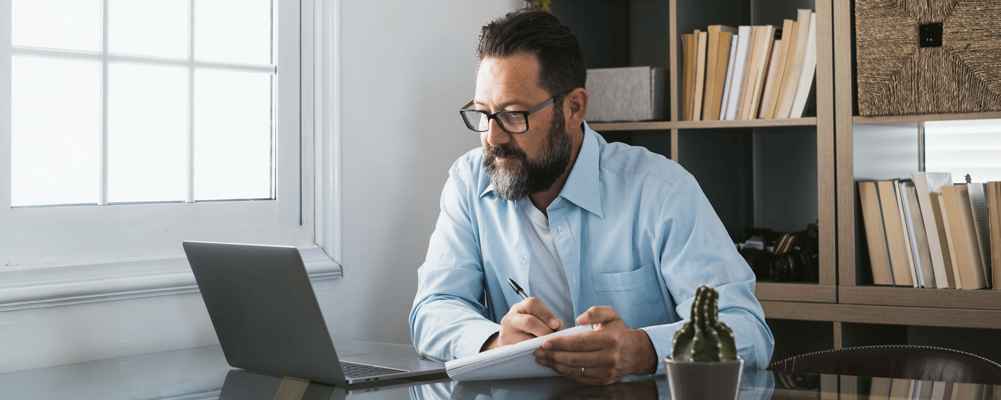 Happy young caucasian businessman smiling working online watching webinar podcast on laptop
