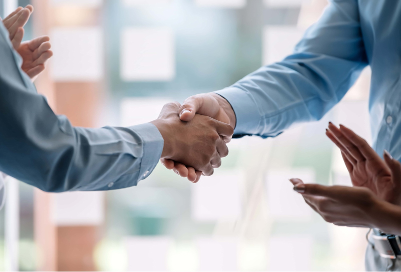 business people at meeting shaking hands to seal a deal