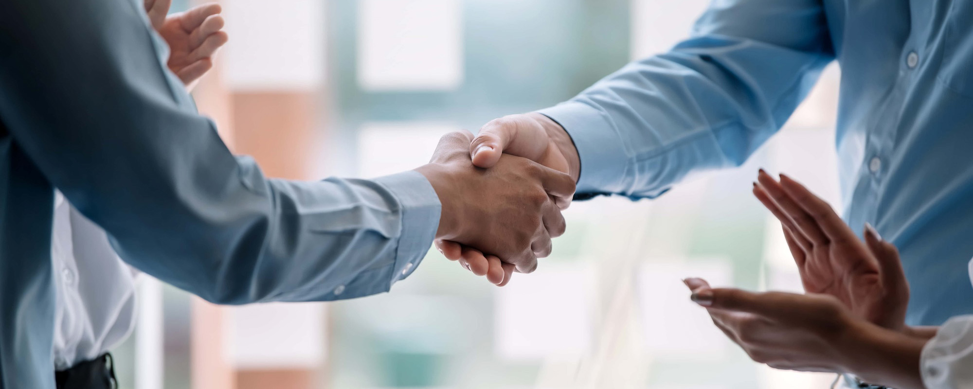 Teamwork of business people at meeting shaking hands to seal a deal with his partner