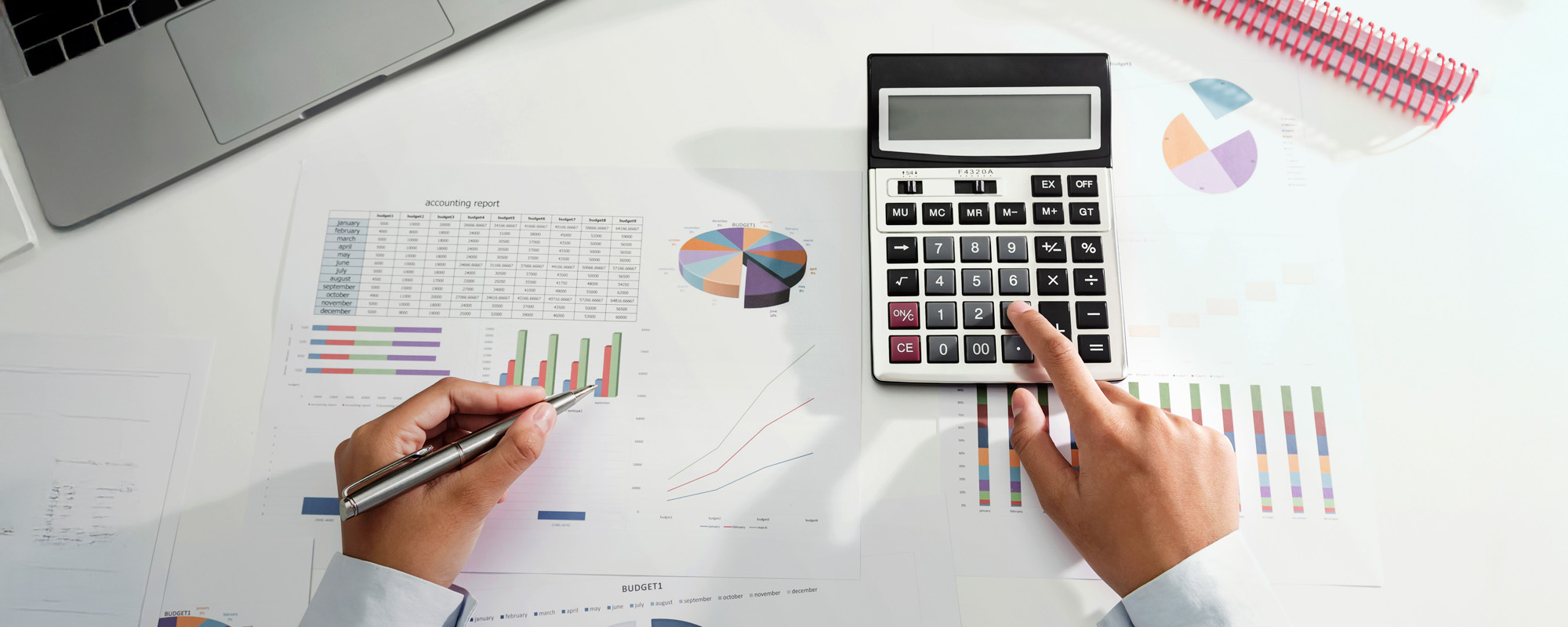 businesswoman working on desk using calculator and laptop analyzing finance accounting in office