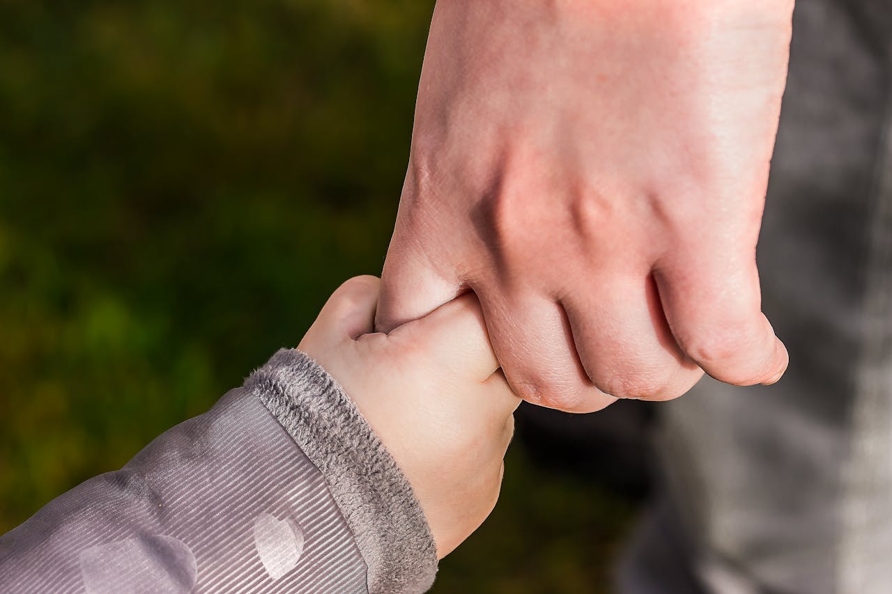 child holding parent's hand